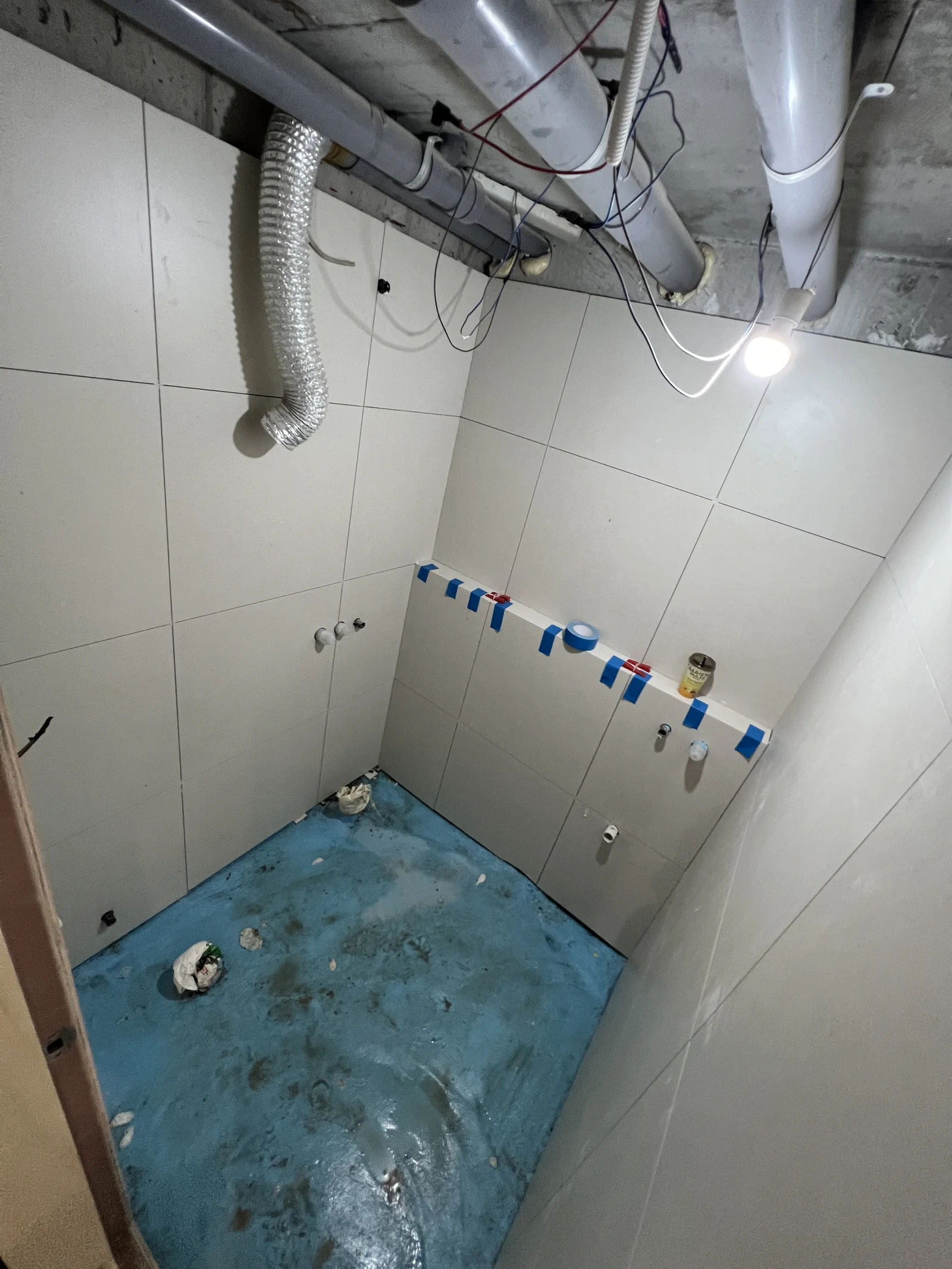 쌍문동 빌라 욕실에 밝은 600각 벽 타일을 시공하고 바닥 작업을 준비하는 모습